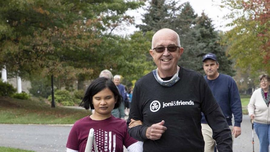 Dick and Maria walking together towards the camera at family retreat.