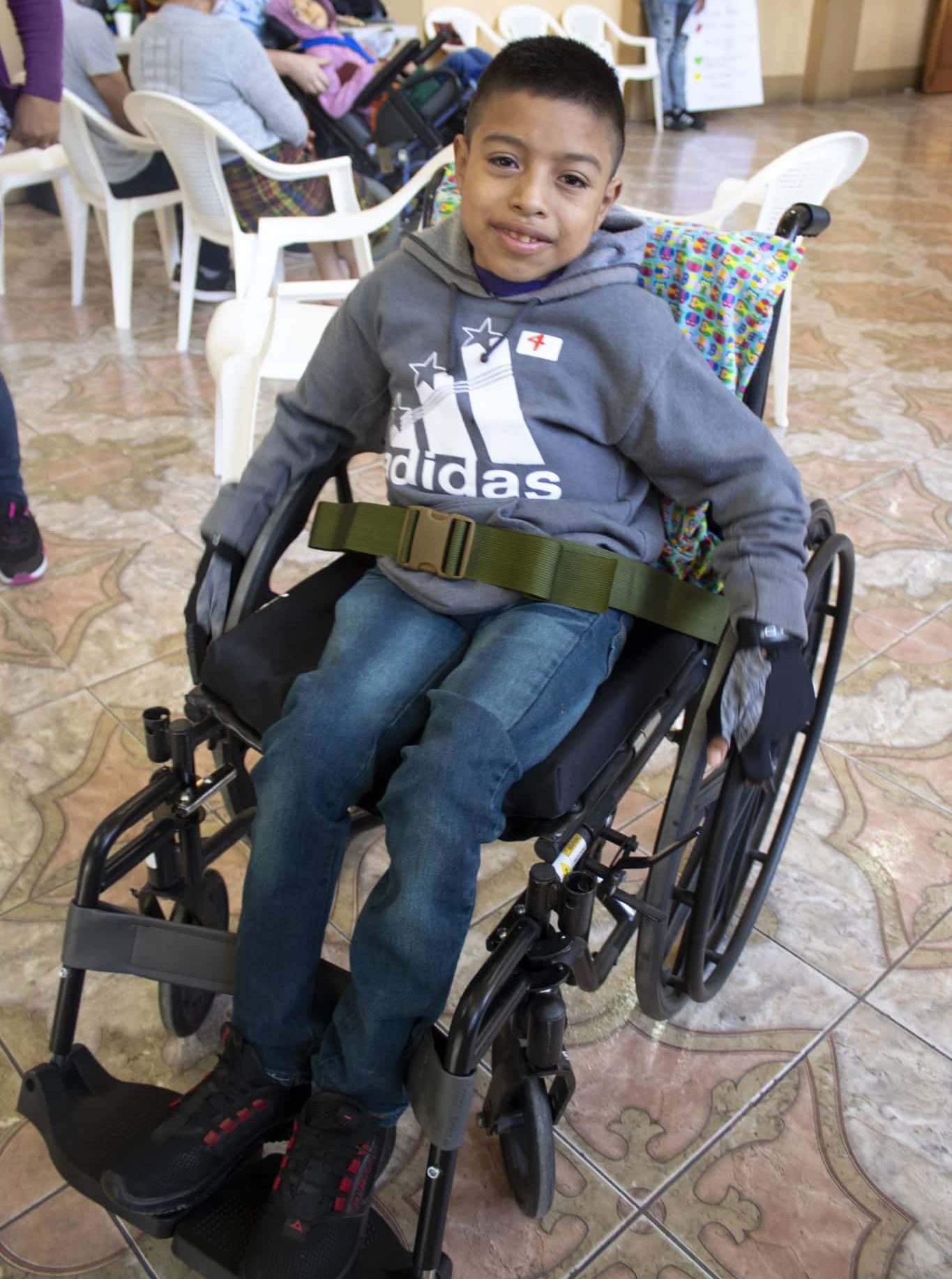A close up of Wilmer smiling wide in his wheelchair.
