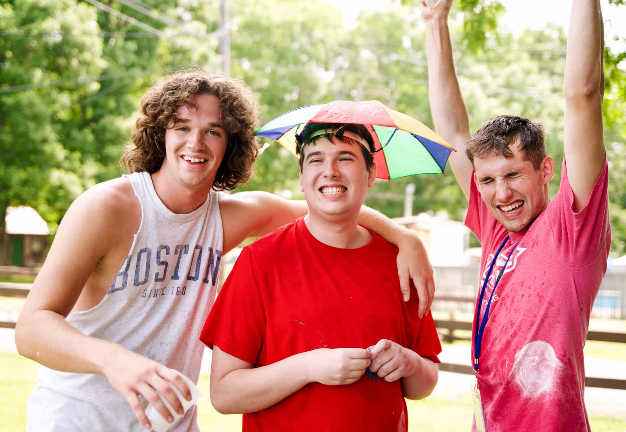 John Paul with an umbrella hat on and his two Joni and Friends volunteers on either side of him.