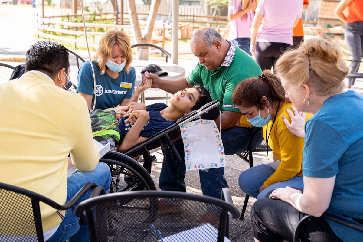 David praying with his parents and some Joni and Friends volunteers.
