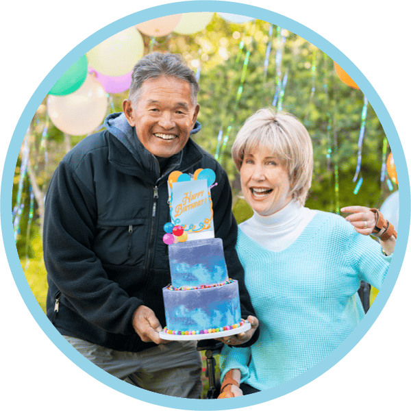 Ken holds a birthday cake next to Joni for her 73rd birthday