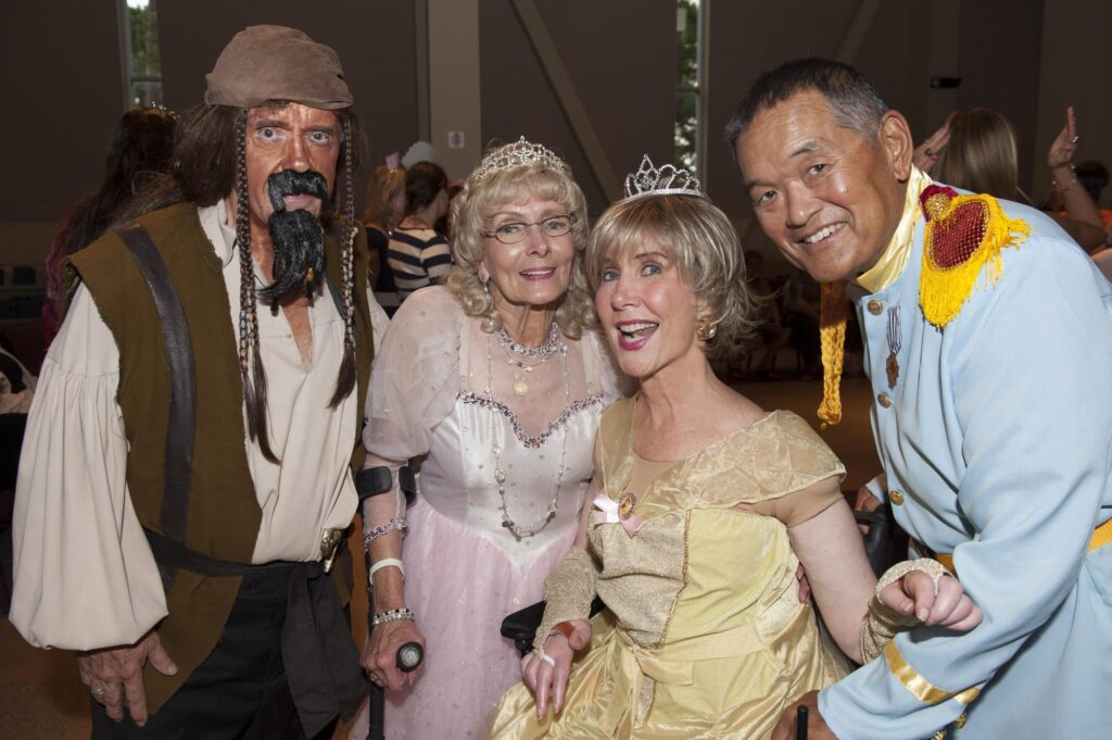 A group picture of Ellen Dibler, her husband Larry, Joni Eareckson Tada and Ken Tada smiling at the camera as they're in their prince and princess costumes.