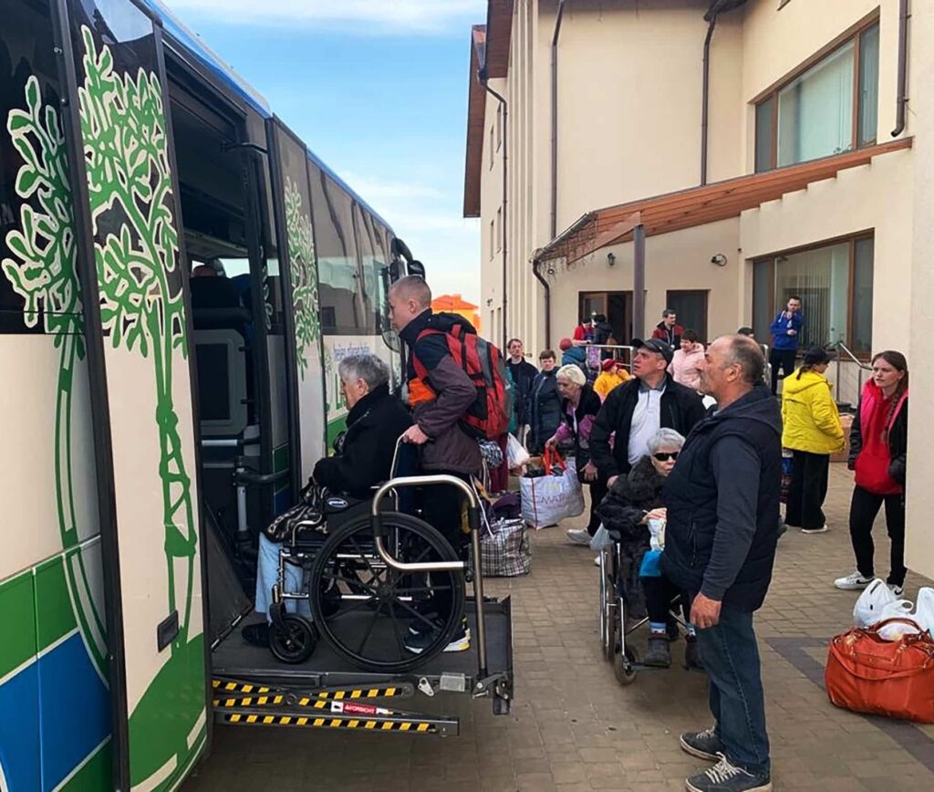 A group of people with various disabilities loading onto a bus.