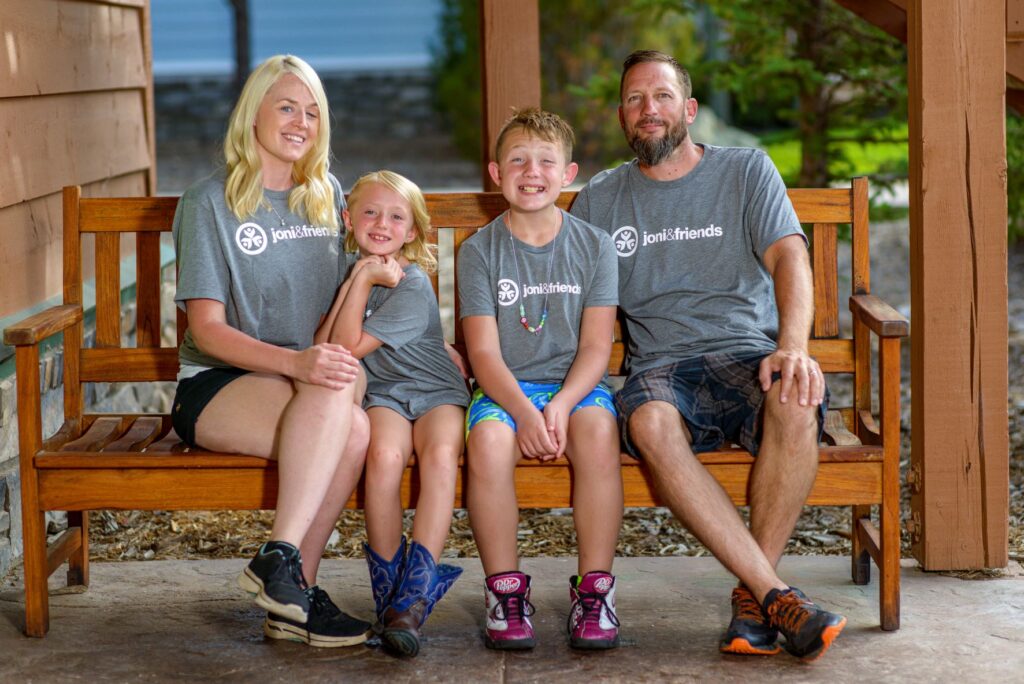 A family photo of Russel, Andrew and their two kids in between them.