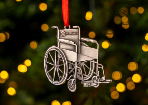 A pewter wheelchair Christmas ornament with the Joni and Friends logo