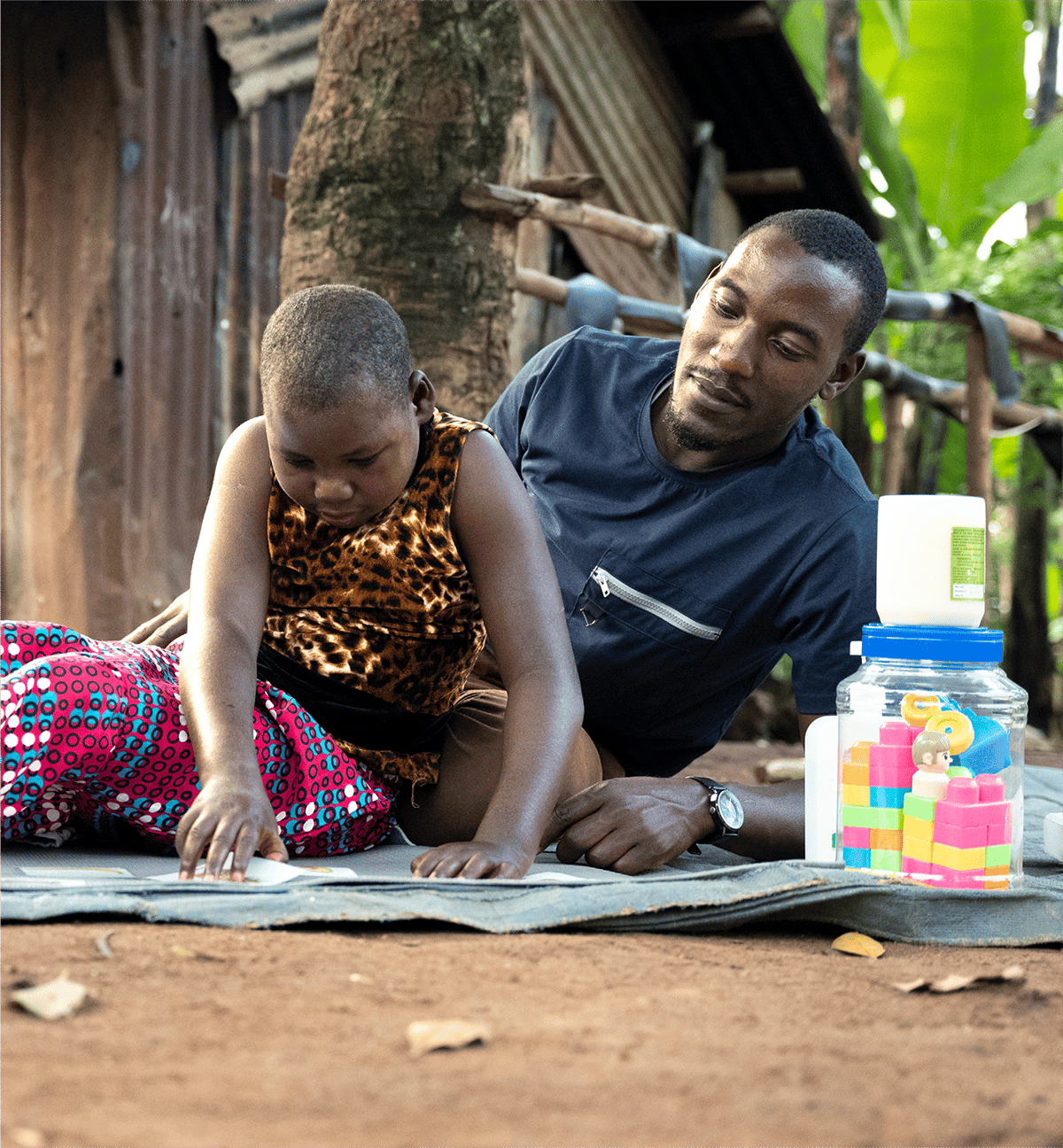 Betty looking down at a piece of paper on the ground as she receives medical care from a Joni's House partner.