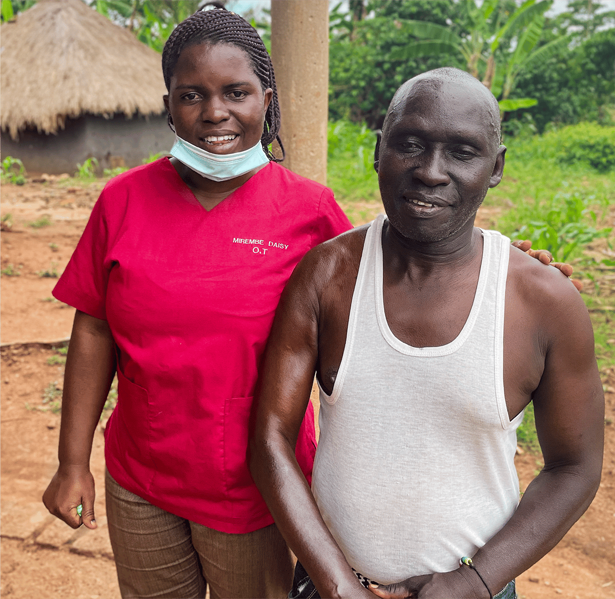 Ashraf and his occupational therapist, Daisy, standing side by side and smiling at the camera.