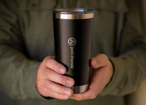 A black and stainless steel tumbler with the Joni and Friends logo