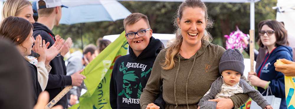 A family is greeted by enthusiastic volunteers as they arrive at Family Retreat.