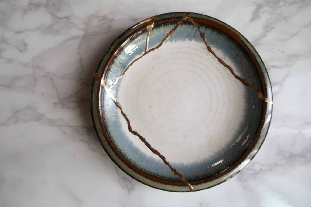 A broken bowl that's been pieced back together with golden lacquer.