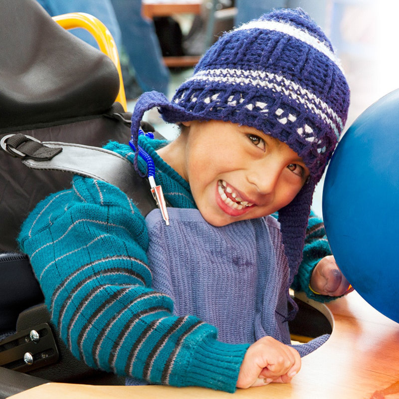 A child smiling in his new wheelchair