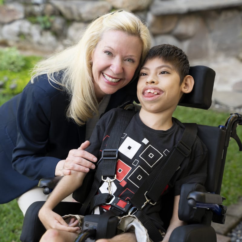 Laura Gardner poses with child in his wheelchair