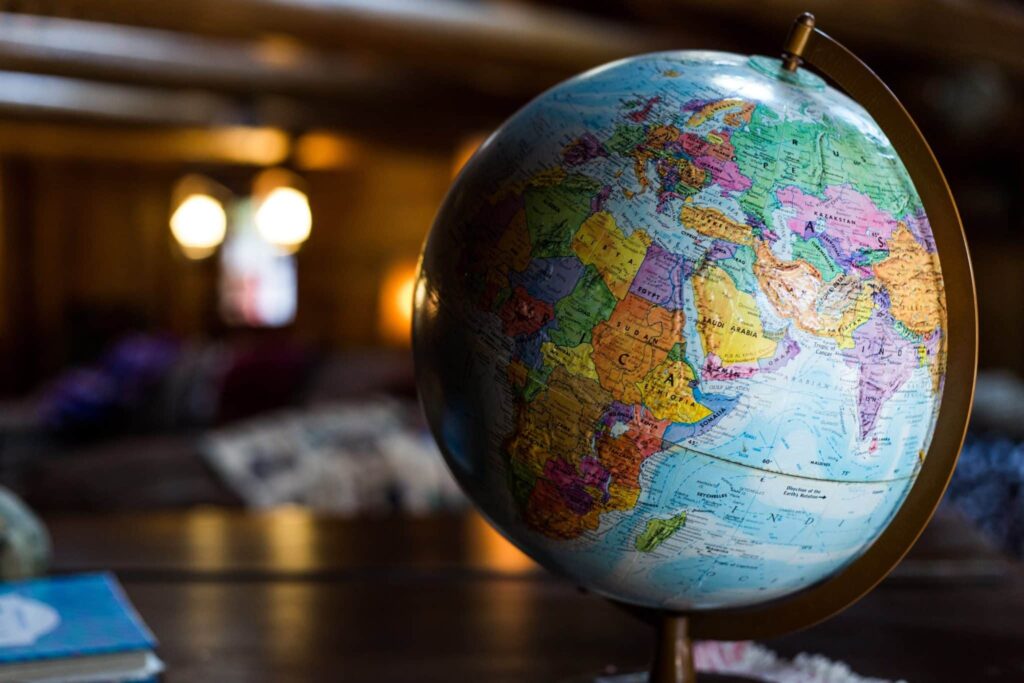 Close up of a multi-colored globe sitting on a desk.