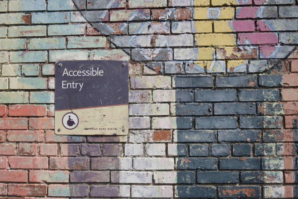 A wall with graffiti on it and a sign that says, "Accessible Entry."