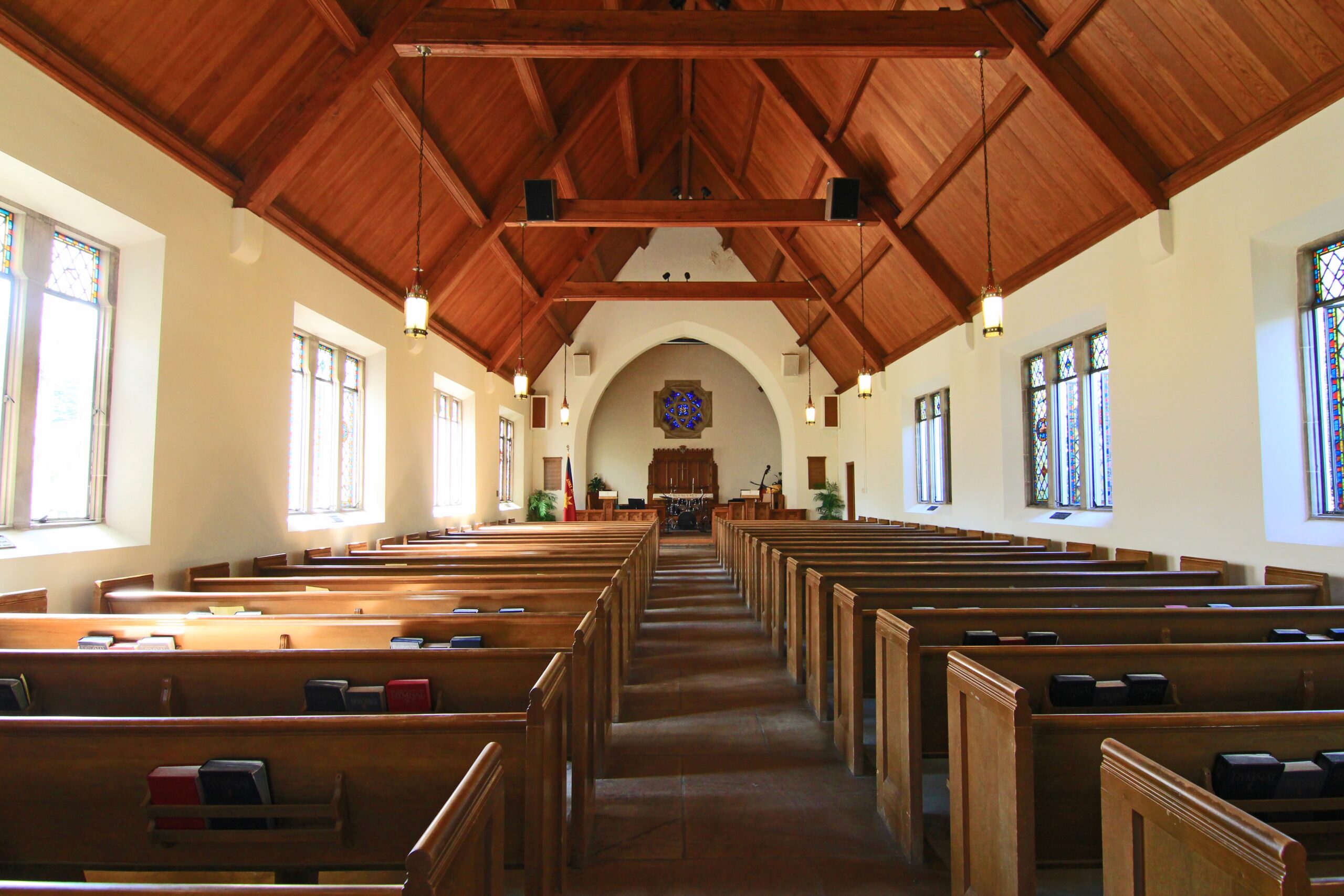 A church with rows of pews and vaulted, wooden ceilings.