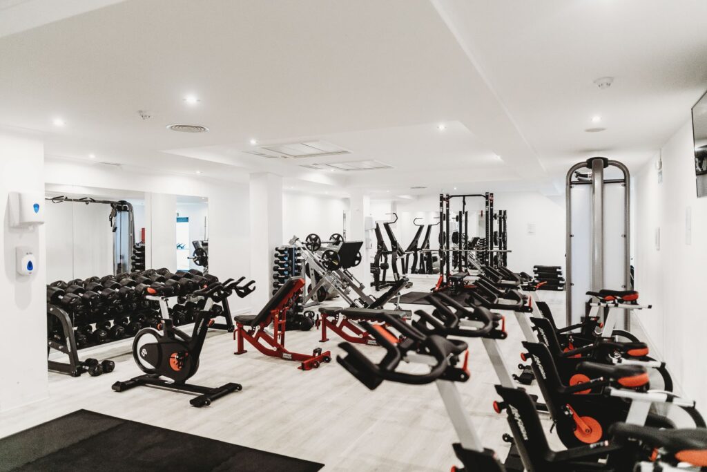 The view of a gym with all of the different machines and weights to the side.