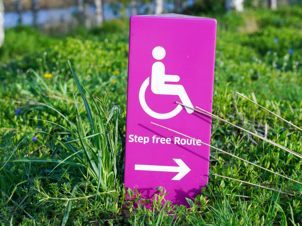 Close up of a pink sign that says "Step Free Route" with an arrow at the bottom.