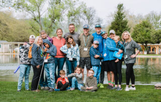 Matt, Marie and their five sons along with other families and their Joni and Friends buddies posing in front of the pond at Family Retreat.