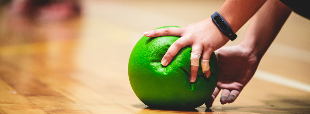 A person holds a green dodgeball