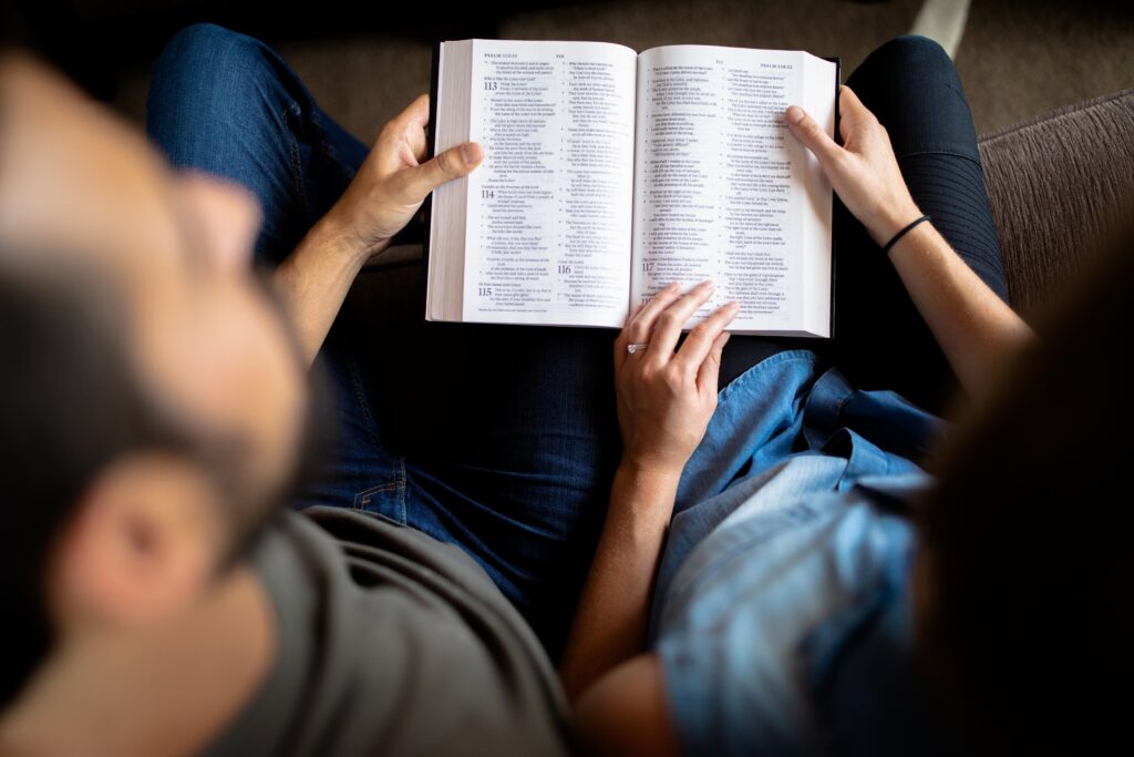 A picture of two people holding a Bible in their lap.