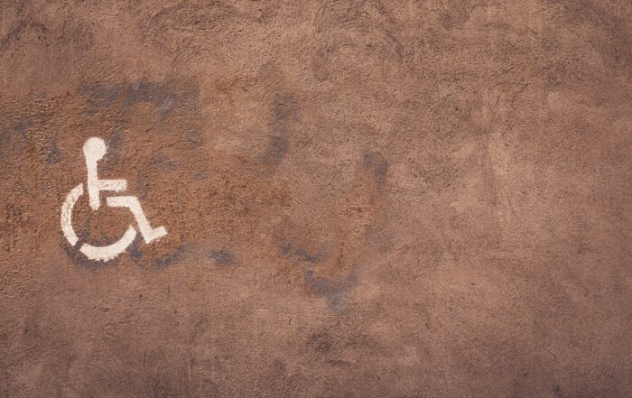 A picture of a handicap symbol spray-painted on cement.