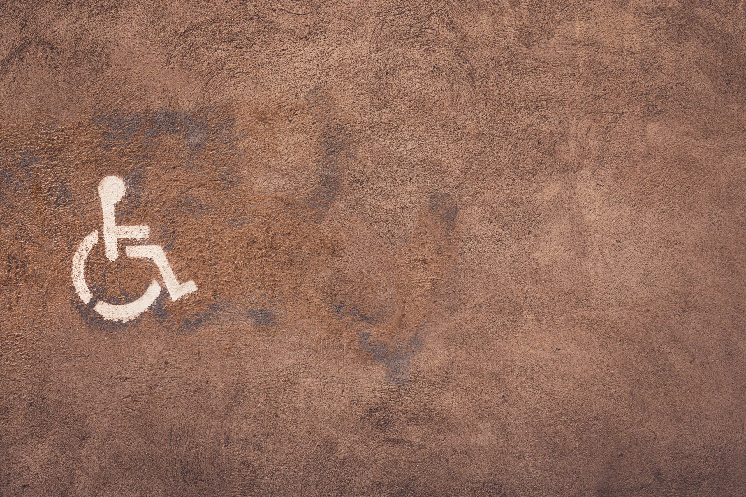 A picture of a handicap symbol spray-painted on cement.