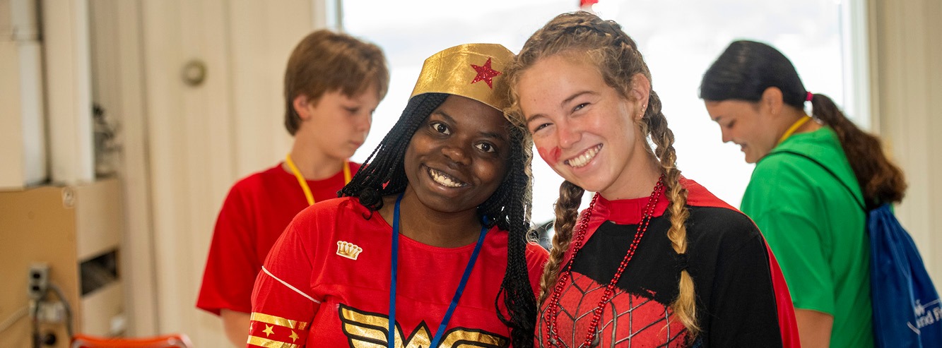 A camper and her buddy are dressed like super heroes, ready to save the day at Family Retreat!