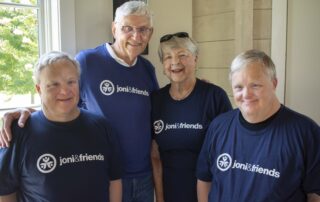 A picture of Sandy, Jim, Mike, and Mark at Family Retreat in their dark blue Joni and Friends tshirt.