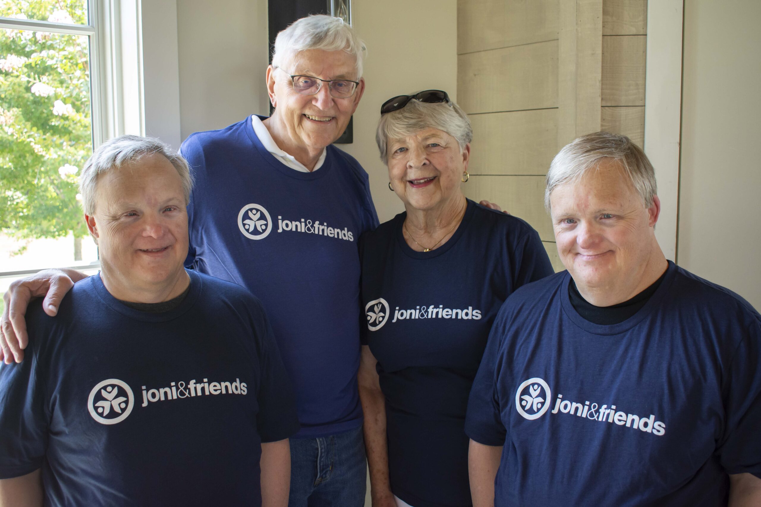 A picture of Sandy, Jim, Mike, and Mark at Family Retreat in their dark blue Joni and Friends tshirt.