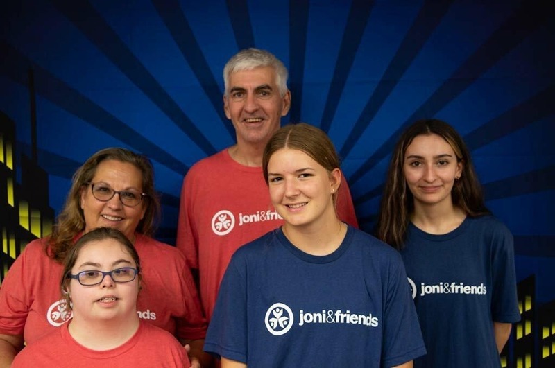 A group photo of Brian, Cheryl, Sophia and their other two daughters all smiling at the camera in their Joni and Friends t-shirts.