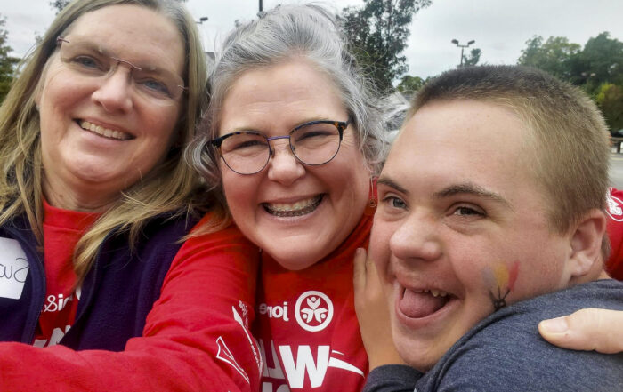 A group picture of Jackson with his mom and another women next to him smiling wide.