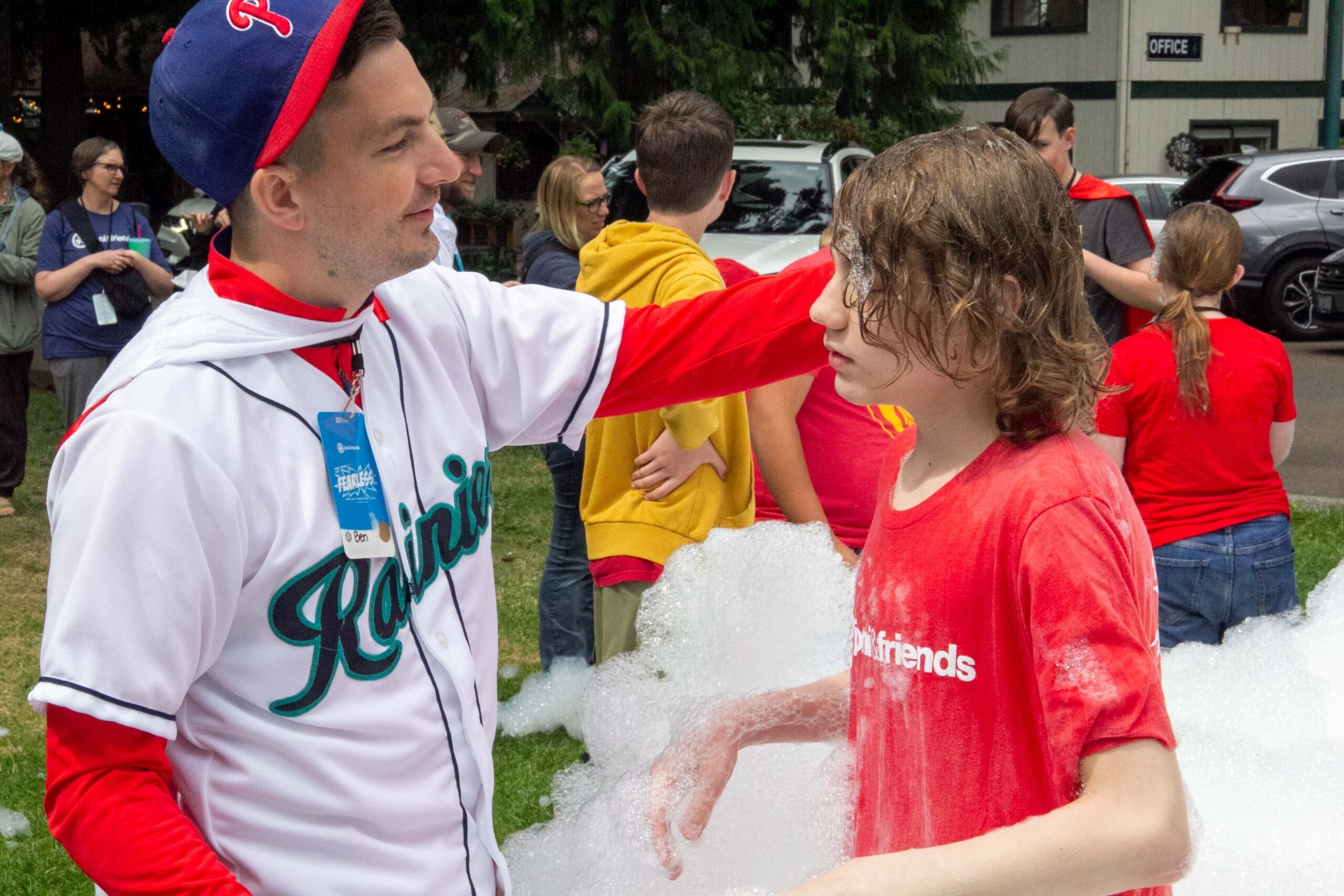 A picture of Ben smiling and reaching out his arm towards a Joni and Friends Retreat attendee as he plays in bubbles.