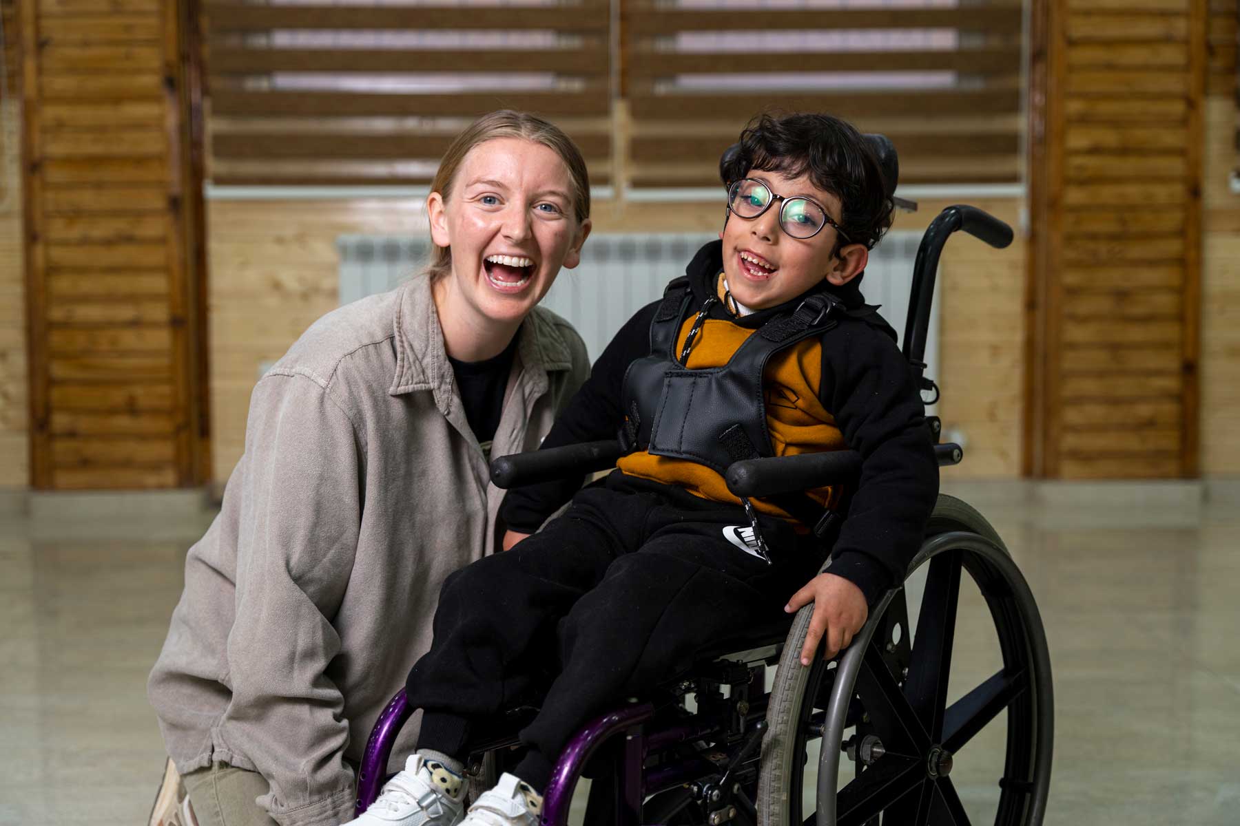 A volunteer and child in their new wheelchair