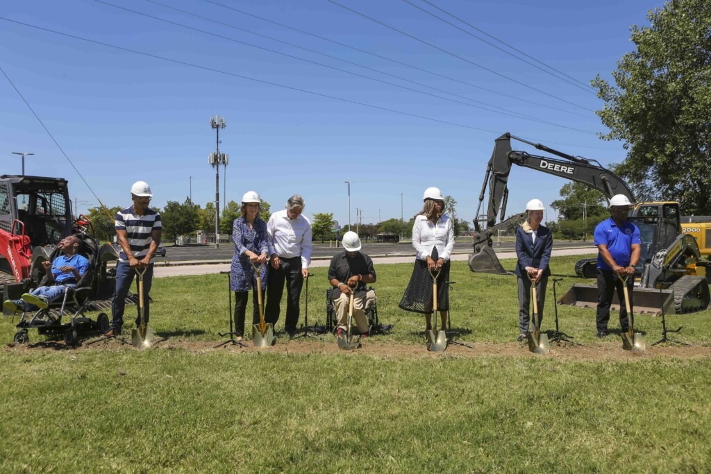 A group photo of eight people standing in a row. Six of them are holding shovels as they break the ground for Joni's House in East St. Louis.