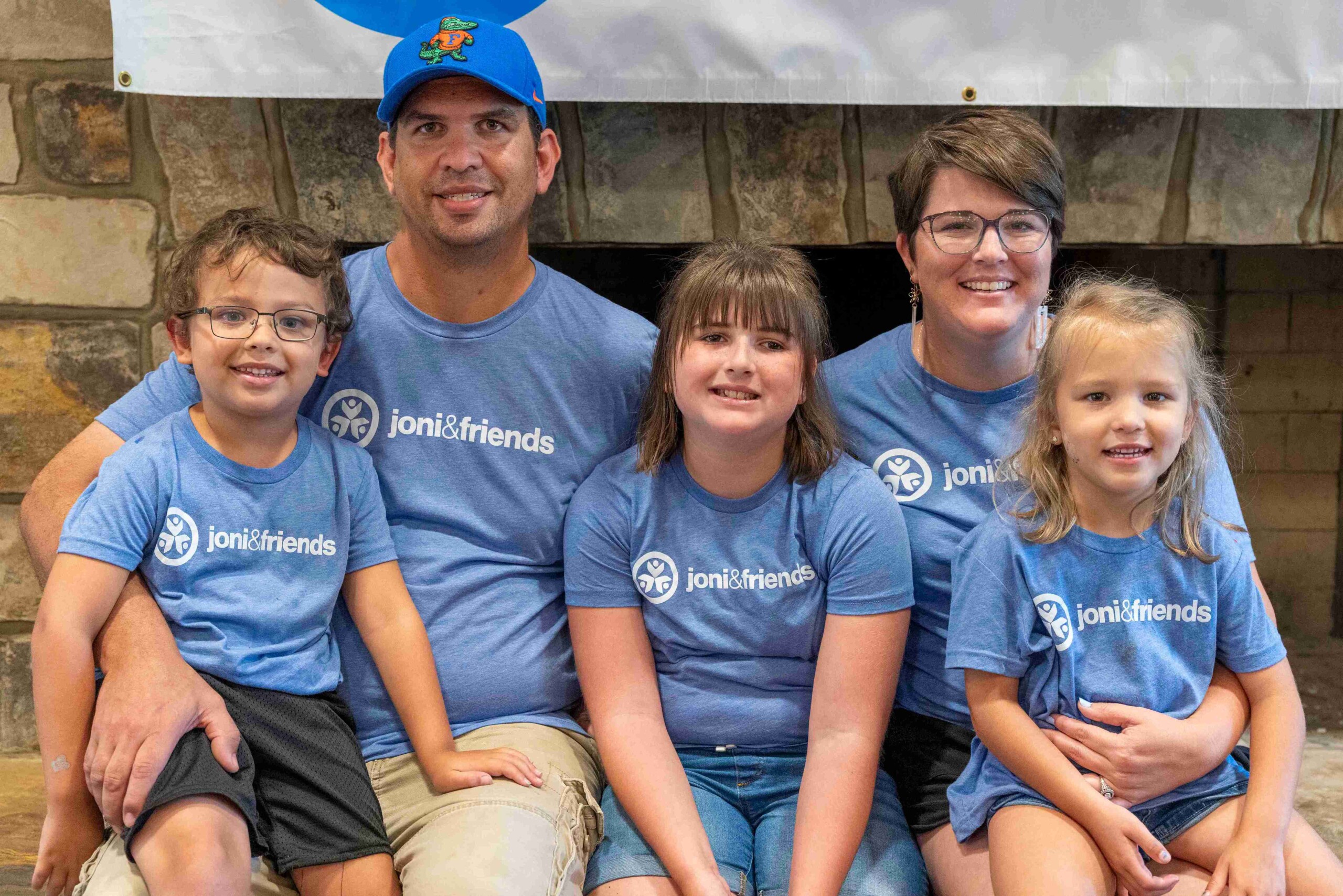 Family photo of five individuals—Charlie, Candice, Huntleigh, Henley, and Haelyn—smiling at the camera during a Joni and Friends family retreat.