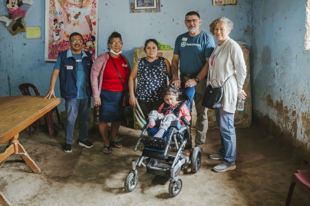 Ashley in her new cub chair indoors with her mom Yolanda and Joni and Friends staff.