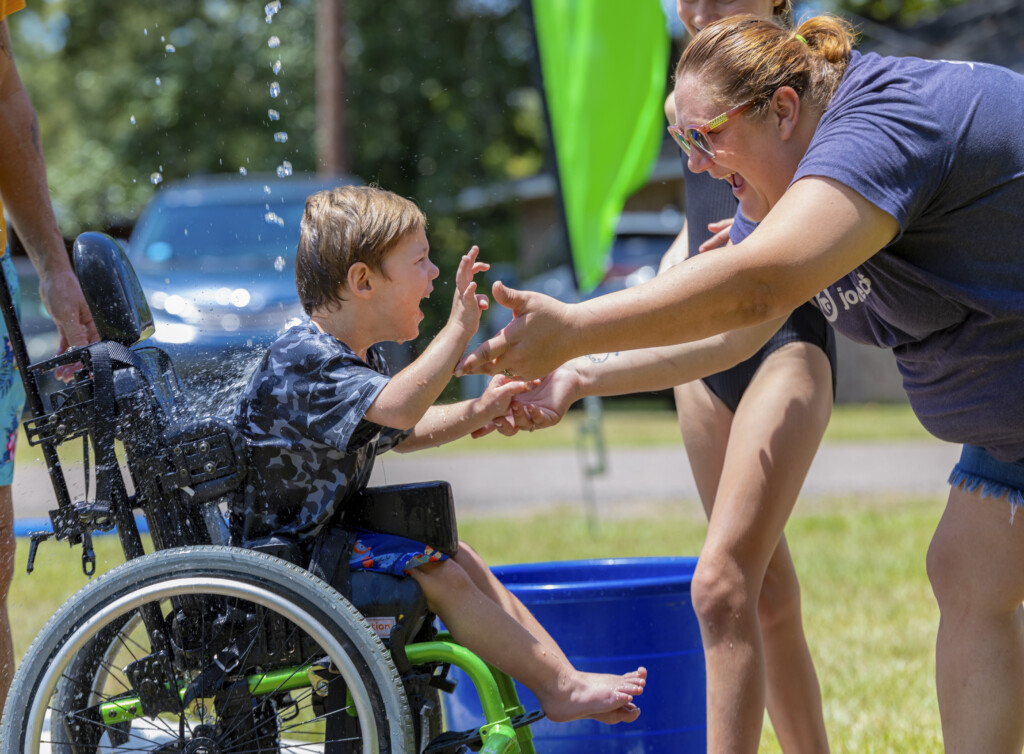 Carson in his wheelchair and Amanda (mom) enjoying Splash Day.