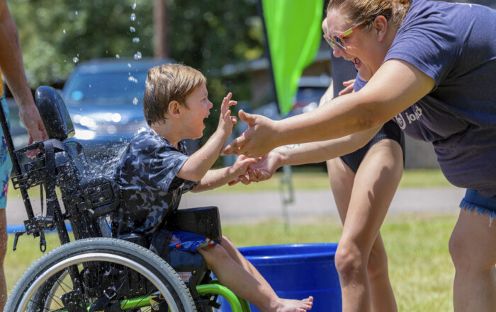 Carson in his wheelchair and Amanda (mom) enjoying Splash Day.