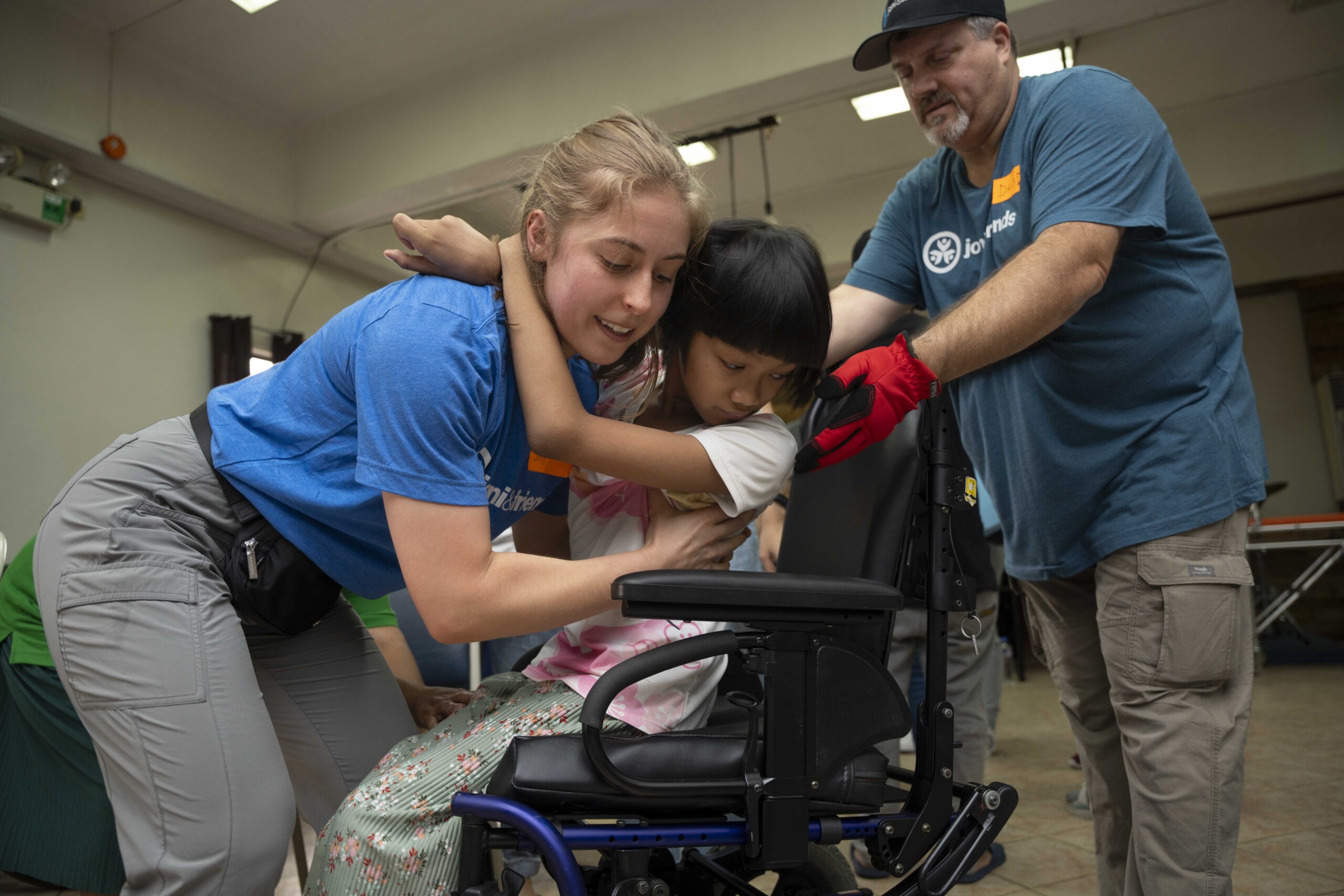 Joni and Friends' staff members assist Daisyry in adjusting to her new cub chair