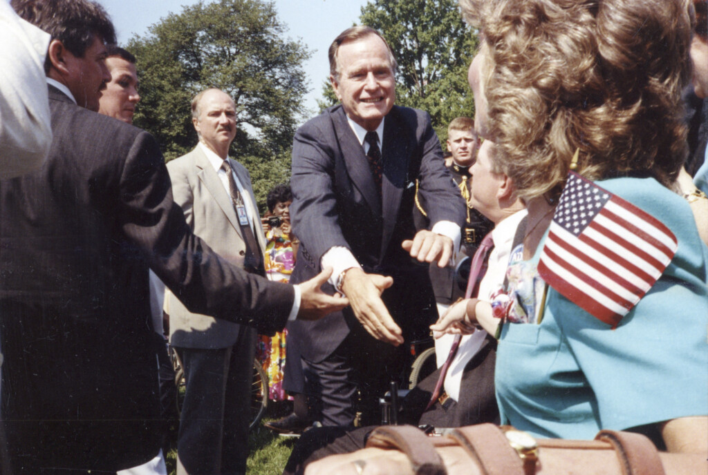 George W. Bush extends a handshake to Joni Eareckson Tada at the signing of ADA.