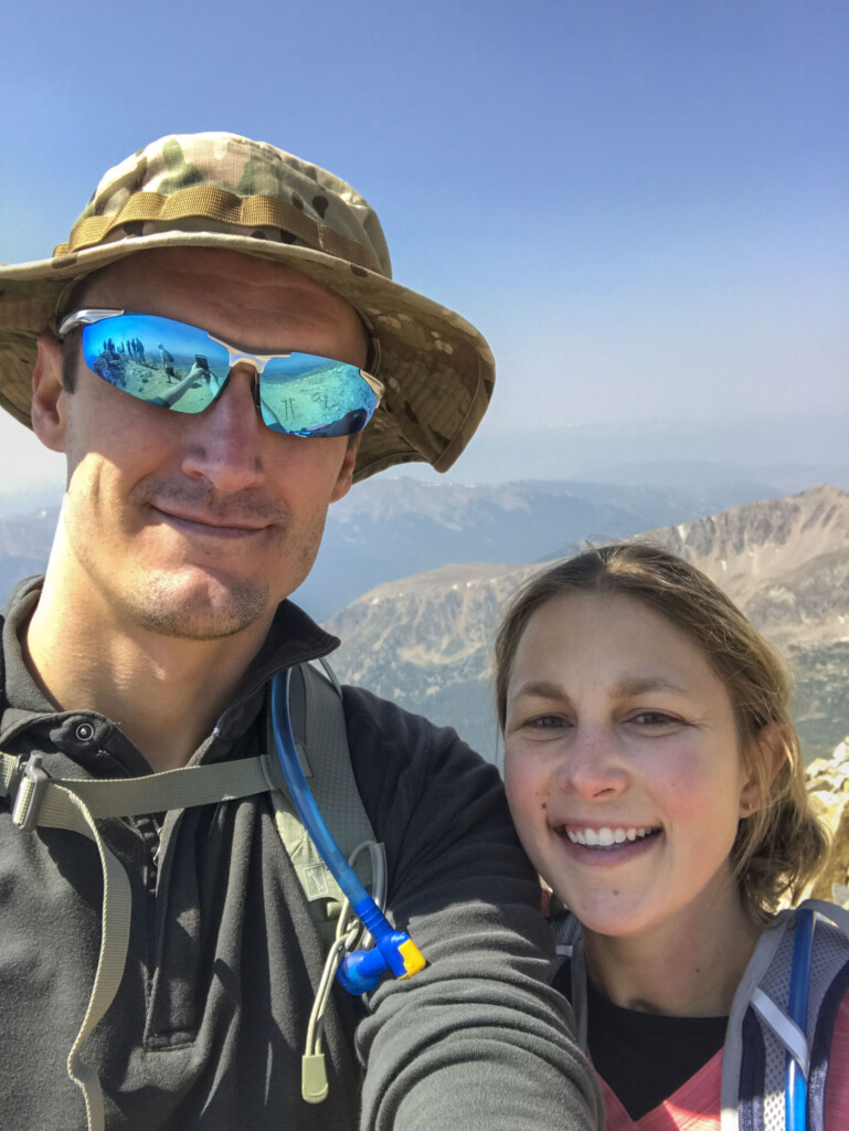 Caleb and Rachel taking a selfie together with a scenic backdrop of mountains below.