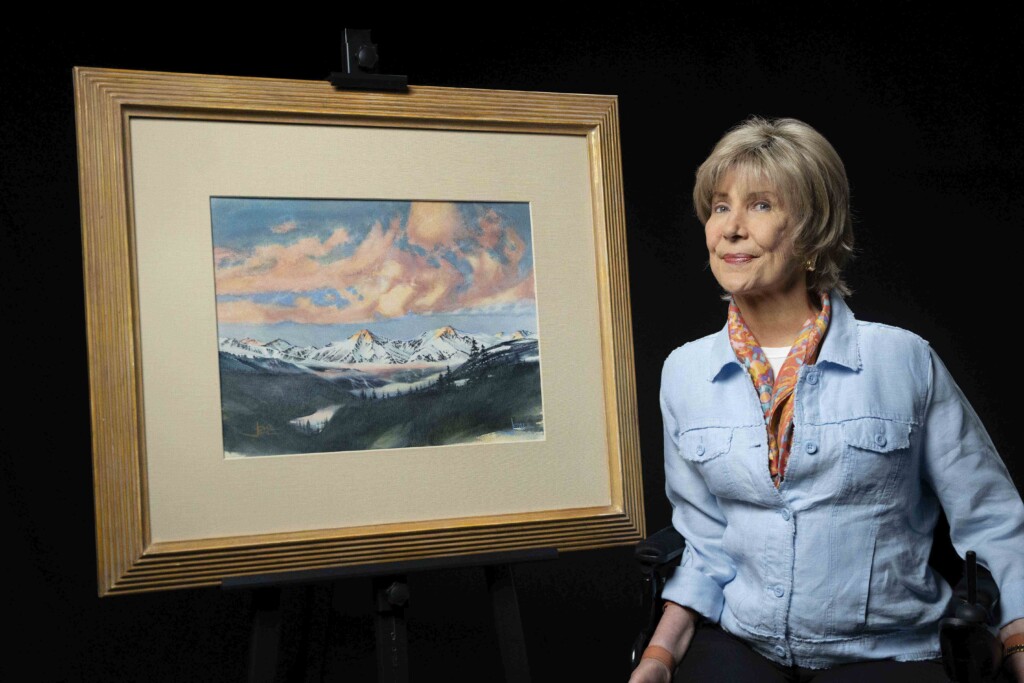 Joni next to her Mountain Majesty artwork.