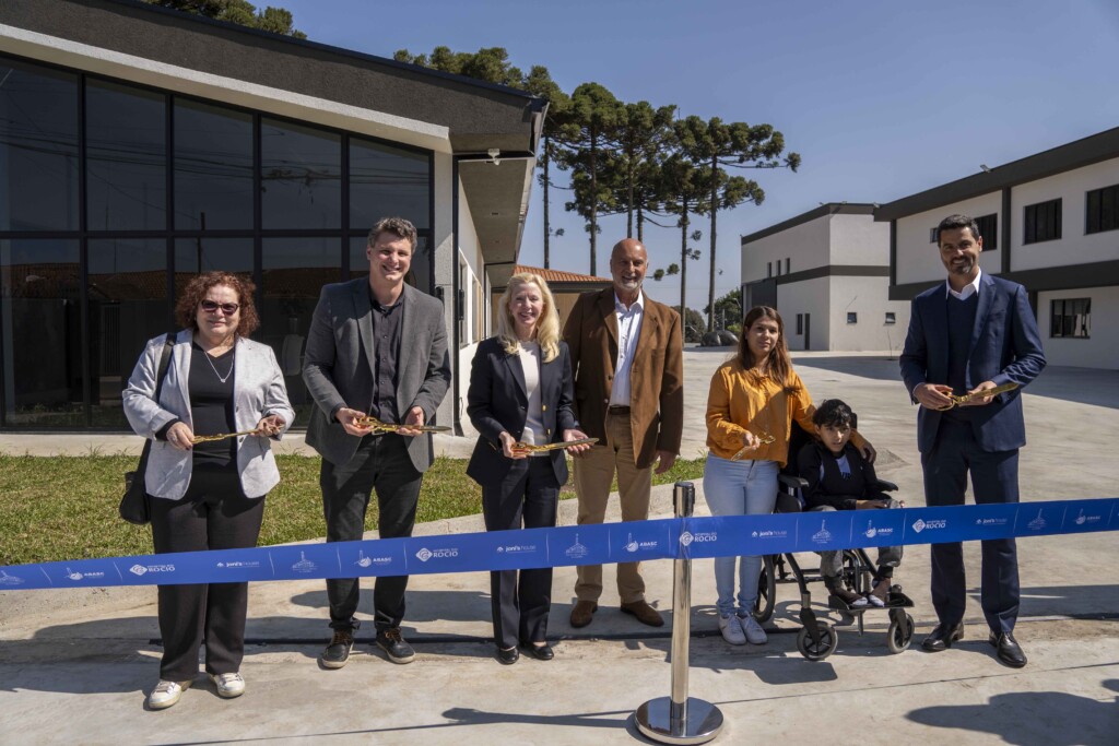 Laura, along with other Joni and Friends staff members and locals from Brazil each holding gold scissors ready to cut the ribbon for the Joni's House Brazil Grand Opening.