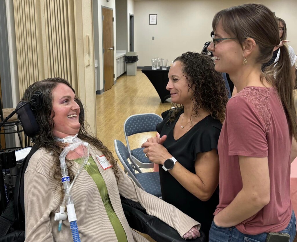 Paige Snedeker talking to two women.