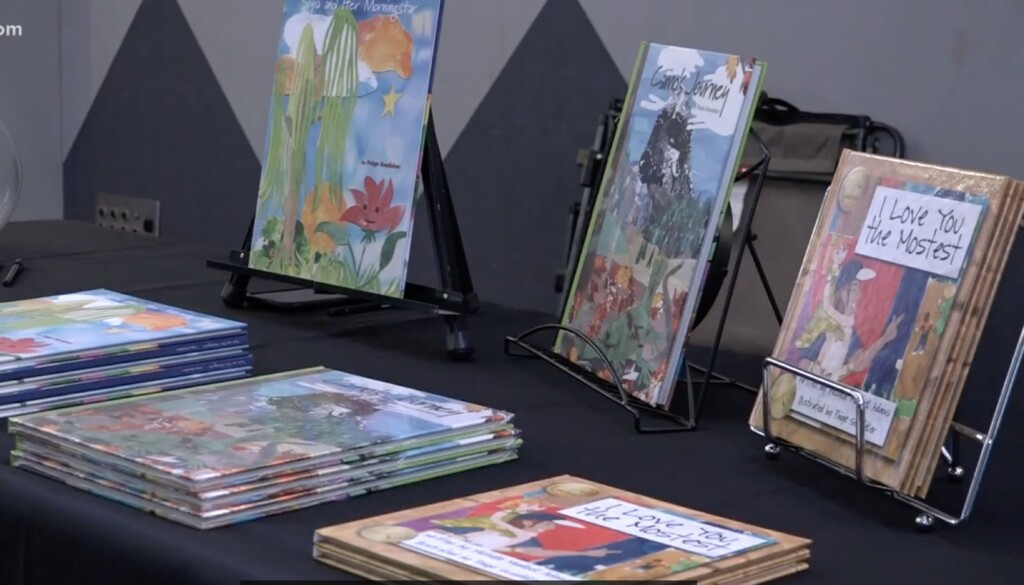 Books that were illustrated or written by Paige Snedeker are displayed on a table.