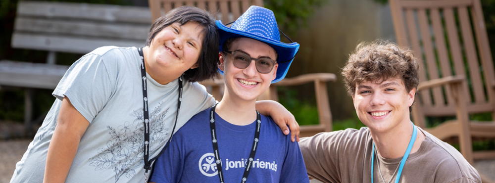 Three people smiling at the camera and putting their arms around each other at the Texas Evening of Hope event.