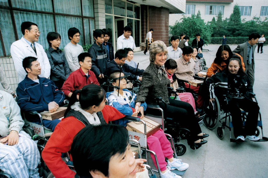 Joni is the middle of a diverse group of individuals, including people with disabilities, staff, and volunteers, during a "Wheels for the World" trip in China.