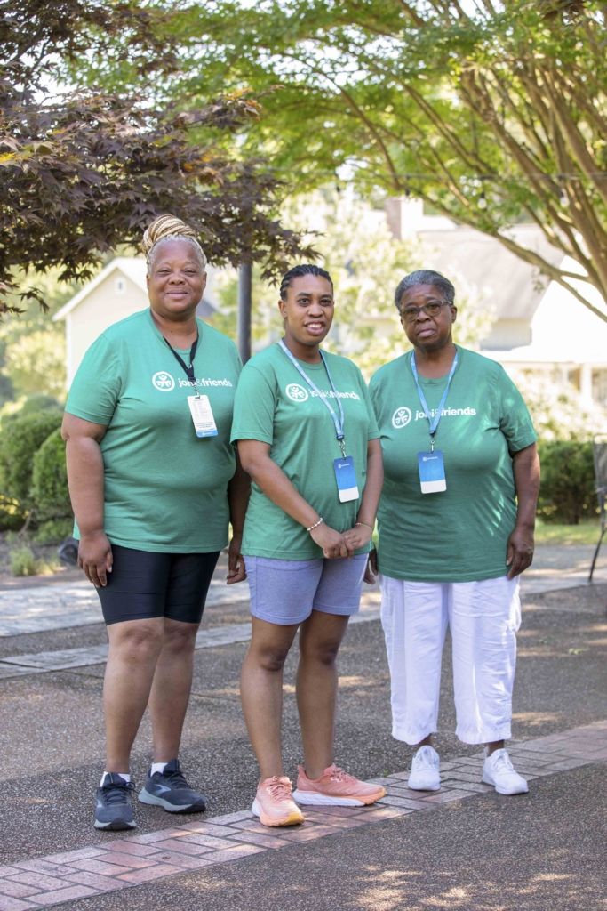 Maxine, Roseanne, and Shirley are standing and posing for the camera, each wearing a green Joni and Friends t-shirt.