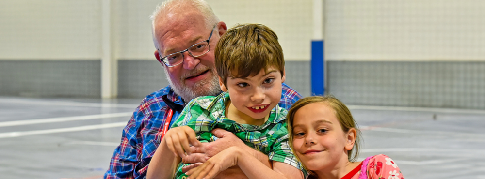 A family of three smiling and posing for the camera during the Joni and Friends Evening of Hope event in Missouri.