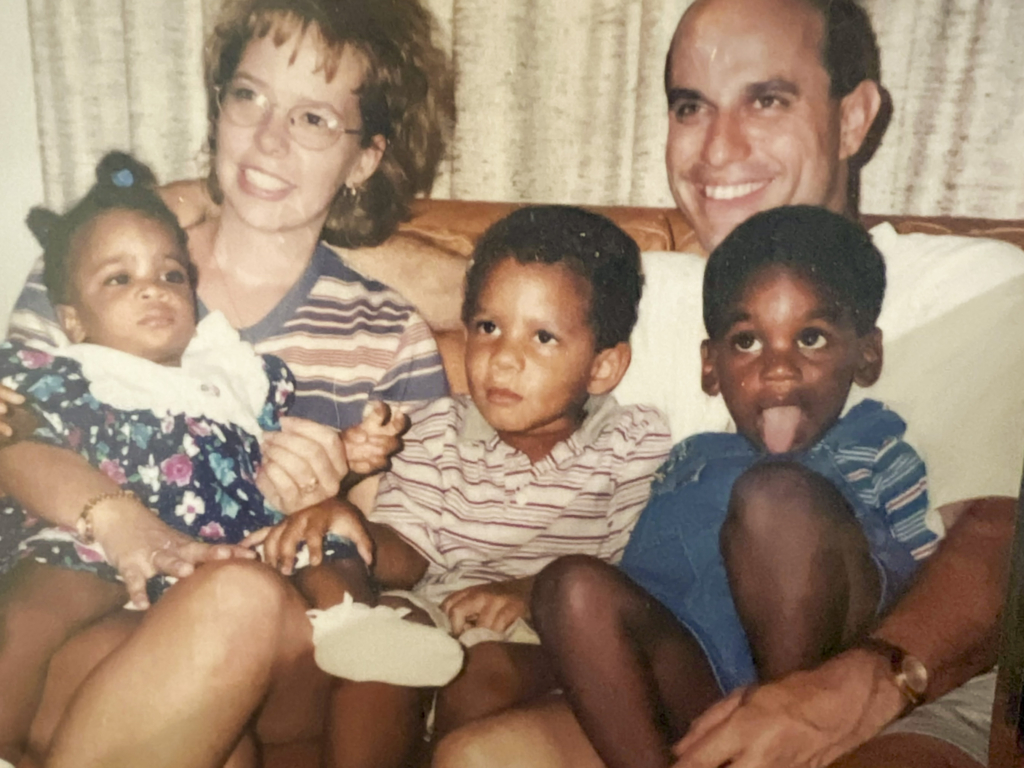 An older picture of Sara Pueblo holding baby Esther while her husband David carries their two sons.